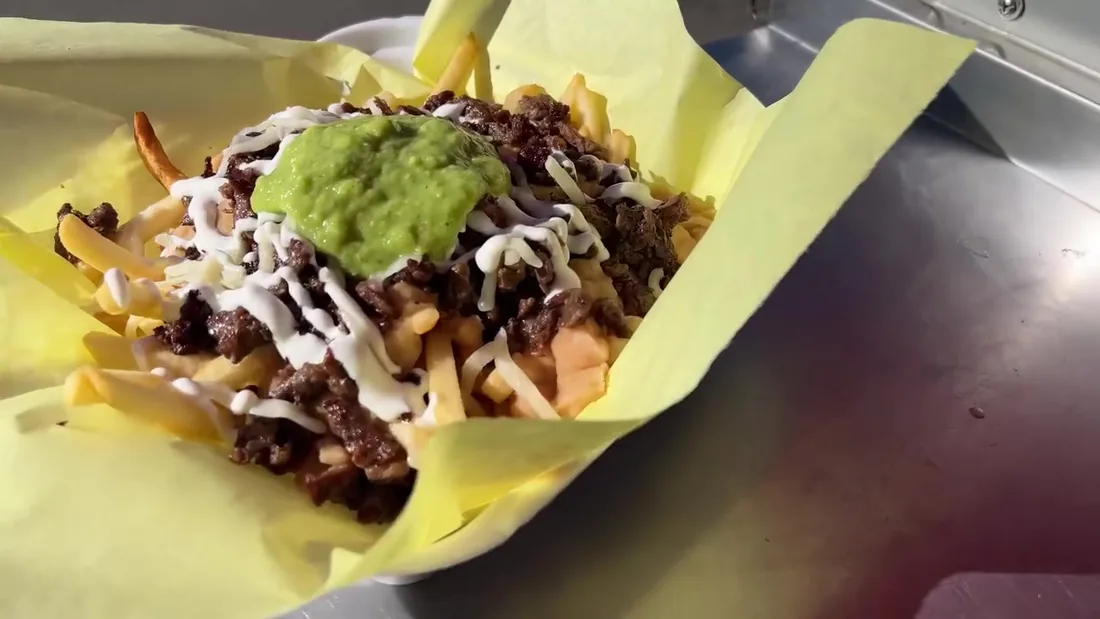 Carne asada fries topped with cheese, meat and guacamole