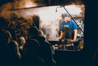 Serranos cook serving from the truck window at a busy evening event