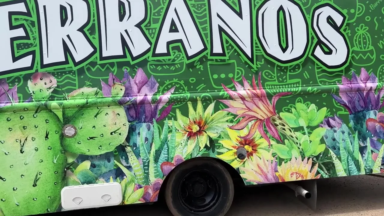 The hand-painted cactus and desert-flower mural on the side of the Serranos Taco Truck
